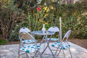 d'une table et de deux chaises avec un vase. dans l'établissement ALBA Amazing Location Beach Apartments, à Biograd na Moru