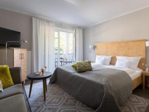 a hotel room with a large bed and a chair at Bodenseehotel Renn in Hagnau +60 photos