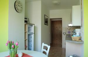 a kitchen with a table and a clock on the wall at Ferienwohnung Wandelt in Arnstadt
