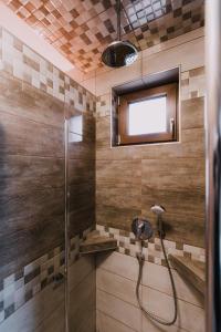a bathroom with a shower with a glass door at Németh Apartmanházak in Mórahalom