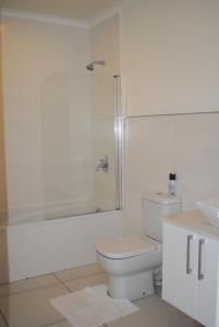 Un baño blanco con inodoro y ducha. en 86 Edison Self Catering, en Johannesburgo 30 fotos más