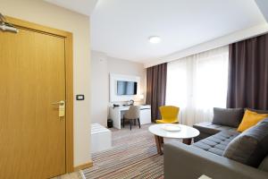 un soggiorno con divano e tavolo di Hotel TESLA - Smart Stay Garni a Belgrado