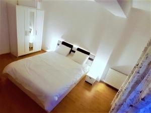 a bedroom with a large white bed with two pillows at Voyage Residence in Mamaia +15 photos