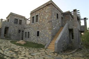 a large stone building with a staircase in front of it at Akvaryum Hotel in Bozcaada
