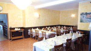 a dining room with tables and chairs with white tablecloths at Hotel Ristorante Amalfitana in Dello