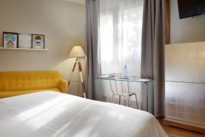 una camera con un letto e una sedia e una finestra di Hotel San Prudentzio a Getaria