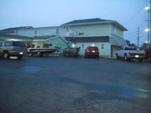un aparcamiento con vehículos estacionados frente a un edificio en Wye Motel en Clinton