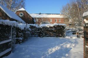 un patio cubierto de nieve frente a una casa en B&B La Chambre d'à Côté, en Aische-en-Refail