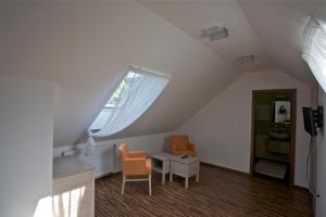a attic room with two chairs and a table and a window at Pútnický mlyn in Marianka