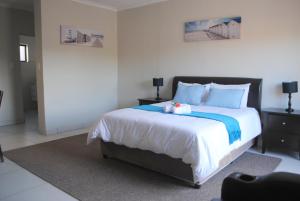Un dormitorio con una cama grande con un osito de peluche encima. en 86 Edison Self Catering, en Johannesburgo