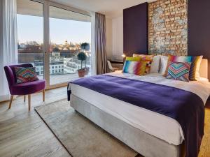 um quarto com uma cama grande e uma janela grande em Hotel Anker Luzern em Lucerna