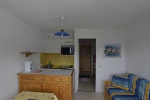 a kitchen and a living room with a couch at Studio Val Gardena 1 in Puy-Saint-Vincent