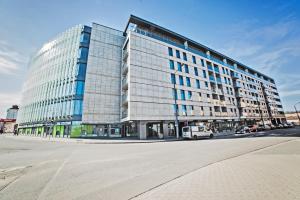 un gran edificio de cristal en una calle de la ciudad en Good Time Apartments Bóżnicza 1 & Małe Garbary 8 - Centrum Poznania, 2 min od Starego Rynku, en Poznan