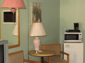 a table with a lamp and a microwave in a kitchen at Satelite Motel in Sault Ste. Marie