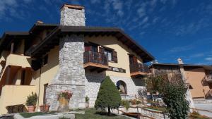 een groot huis met een stenen schoorsteen en balkon bij Hotel Altopiano Delle Rocche in Rocca di Mezzo