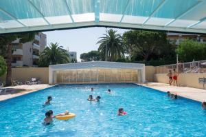 a group of people swimming in a swimming pool at Résidence Héliotel Marine in Saint-Laurent-du-Var