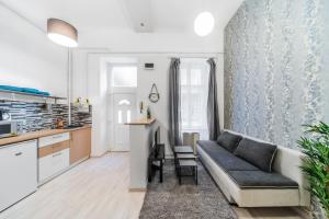 a living room with a couch and a kitchen at Barcsay Apartment in Budapest