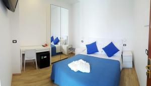 a bedroom with a blue bed with blue pillows and a desk at Hotel Mare Blu -- boutique in Pineto