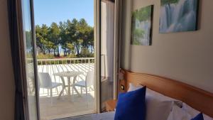 a bedroom with a bed and a balcony with a table and chairs at Hotel Mare Blu -- boutique in Pineto
