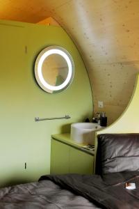 a bedroom with a circular mirror and a sink at Rüedi - Fasstastische Ferien in Trasadingen