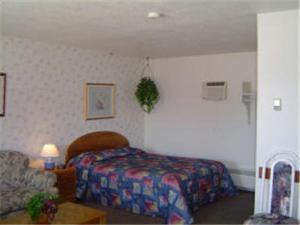 1 dormitorio con 1 cama y 1 silla en una habitación en Carravalla Inn, en Melfort