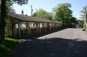 un edificio con mesas y sillas junto a una carretera en Skyline Motel, en Sault Ste. Marie