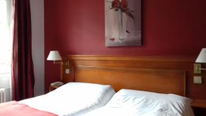 1 Schlafzimmer mit 2 Betten und einer roten Wand in der Unterkunft Logis Hôtel-Restaurant Les Airelles in Neufchâtel-en-Bray