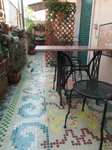 un patio con mesa y sillas en un suelo de mosaico en Abitazione Pigneto B&B, en Roma