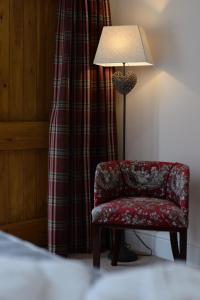 a room with a red chair and a lamp at The Red Lion, Barn Accommodation in Thornby