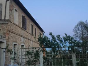 a brick building with a fence next to it at Il Rudere in Ravenna