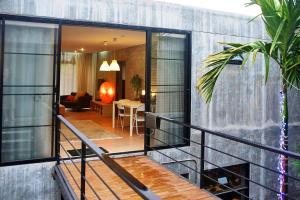 a balcony of a house with a living room at Baan Mali Apartment in Chiang Mai