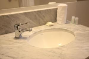 a bathroom sink with a faucet and a roll of toilet paper at Buen Pastor Capuchinos in Cordoba