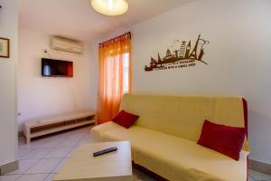 a living room with a yellow couch and a table at Apartman Astrid in Veli Lošinj
