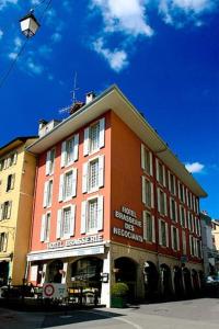 ein großes orangefarbenes Gebäude an der Seite einer Straße in der Unterkunft Les Negociants in Vevey