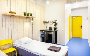 a small room with a bed and a yellow door at Hektor Design Hostel in Tartu
