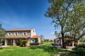 a large stone house with a grass yard at Villa Rea in Umag