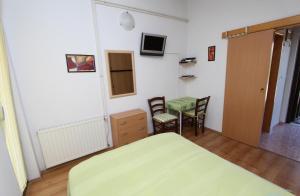 een slaapkamer met een bed en een tafel en stoelen bij Studio and Room Tea in Rovinj