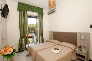 a bedroom with a bed and a balcony at Hotel Giulio Cesare in Rapallo