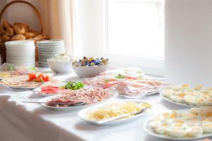 une table avec de nombreuses assiettes de nourriture dans l'établissement Hotel Gasthof Metzgerei Lamm, à Geiselwind