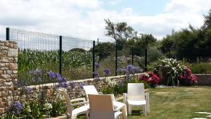 ブリニョガン・プラージュにあるGîte de Porspolの白い椅子と紫の花が咲く庭園