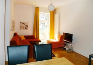 ein Wohnzimmer mit einem Sofa und einem TV in der Unterkunft City Apartments Wien - Viennapartment in Wien