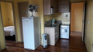 a kitchen with a refrigerator in the middle of a room at Pousada Campanário in Cambará