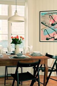 a dining room table with a vase of flowers on it at House of the Snowbird in Reykjavík