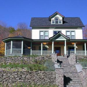 a large white house on top of a stone wall at Breezy Hill Inn in Fleischmanns