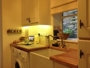 a kitchen with a sink and a dishwasher at Snowdonia Snug - Studio Style Accommodation in Dolgellau