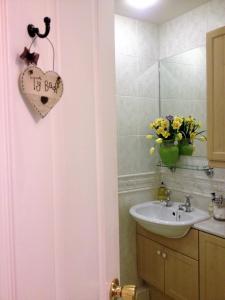 een badkamer met een wastafel en een hartteken op de deur bij Snowdonia Snug - Studio Style Accommodation in Dolgellau