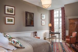 a bedroom with a bed and a chair and a mirror at Chateau des Grotteaux Près Chambord in Chambord +29 photos