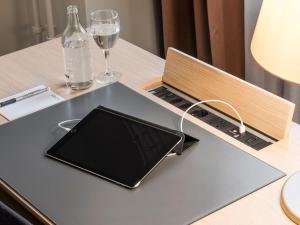 un ordenador portátil sentado en una mesa con una botella y gafas en Hotel Savoy, en Berna