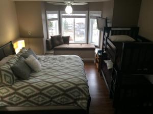 a bedroom with a bed and a couch and a window at Heart of Peachland in Peachland