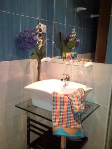 コラレホにあるCasa El Pozoのバスルーム(ガラスのテーブルにタオルをかけたシンク付)